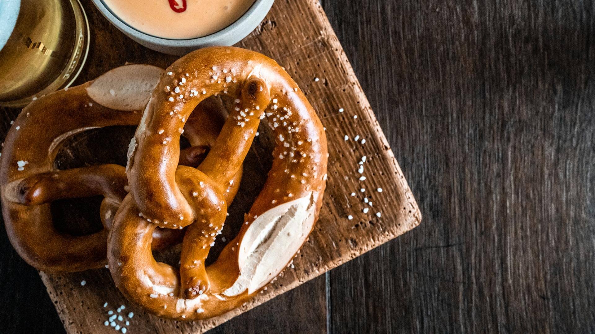 Käsedip orientalisch mit Laugenbrezeln auf Holzbrett