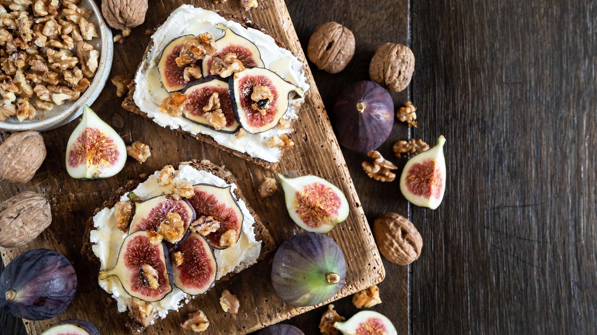 Karamellisiertes Dinkelbrot mit Ricotta und Feige auf Holztisch