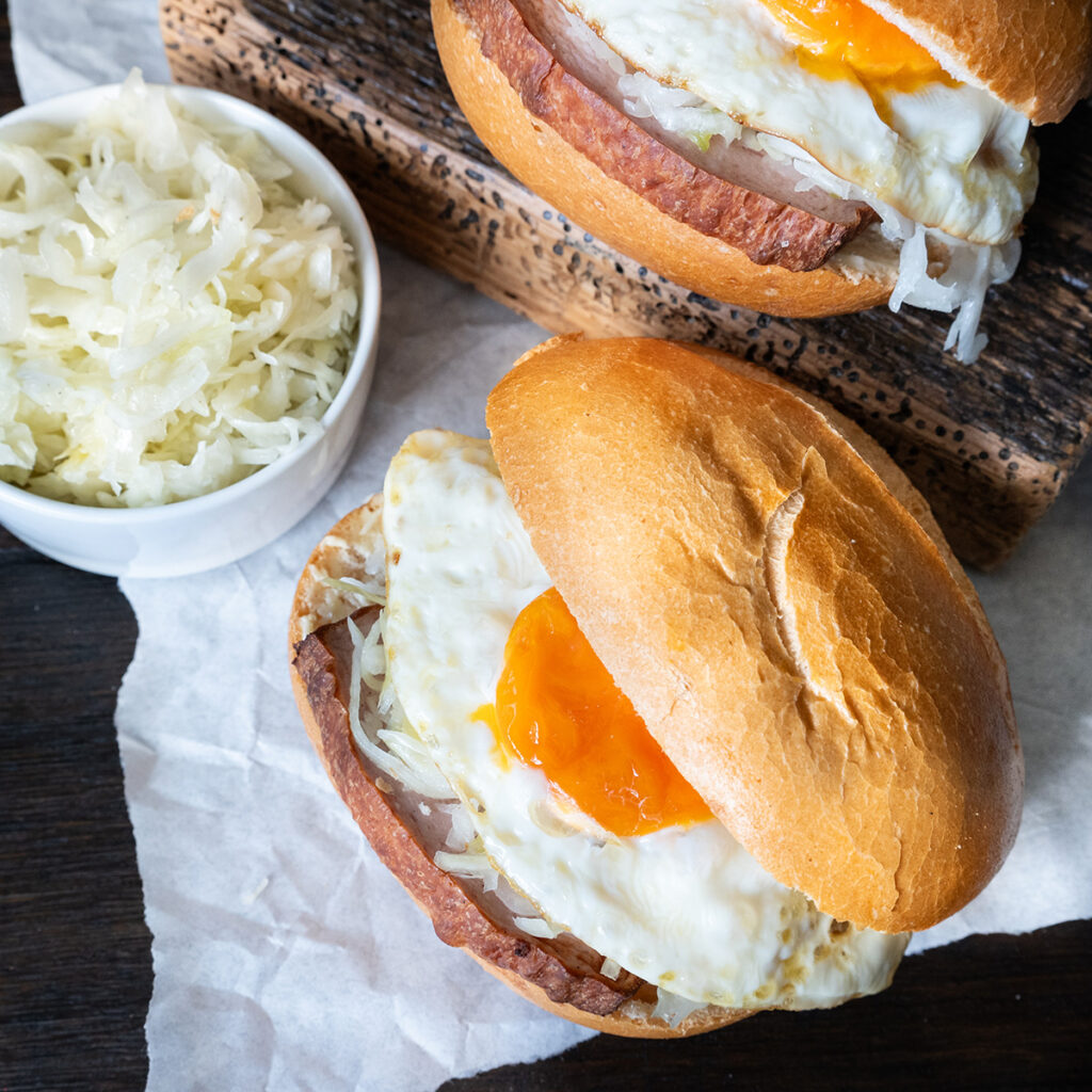 Fleischkäse-Ei-Brötchen auf einem Holztisch